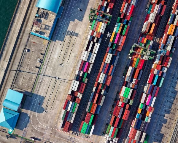 Top view of colorful shipping containers at a bustling port in Jakarta, Indonesia.